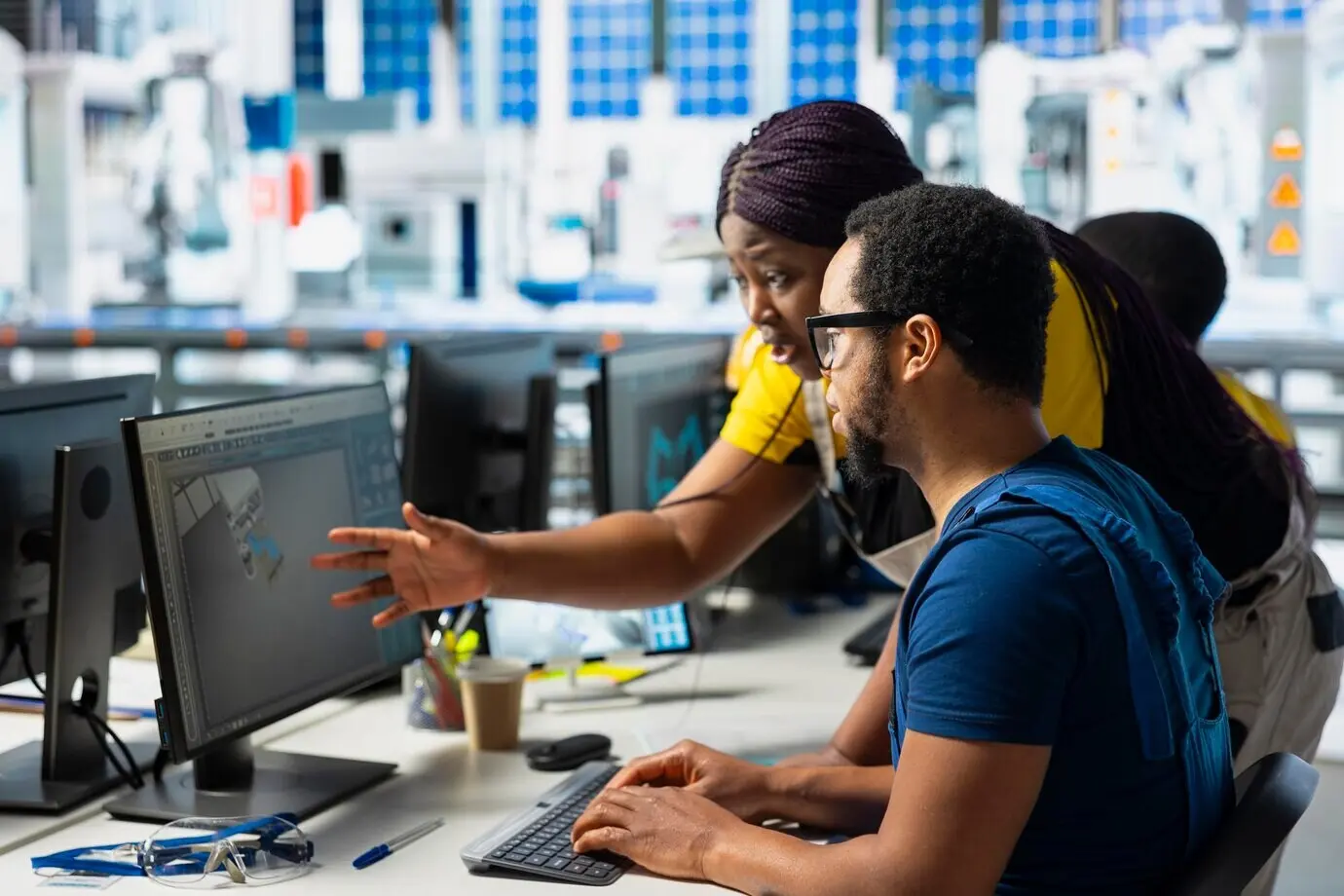 An African American engineering team performing quality control on a computer setup.